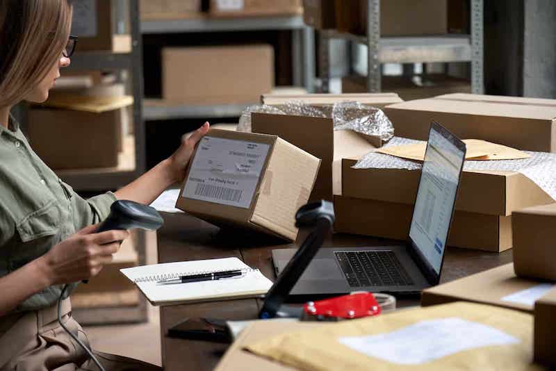 ecommerce fulfillment concept woman scanning shipping boxes in a warehouse