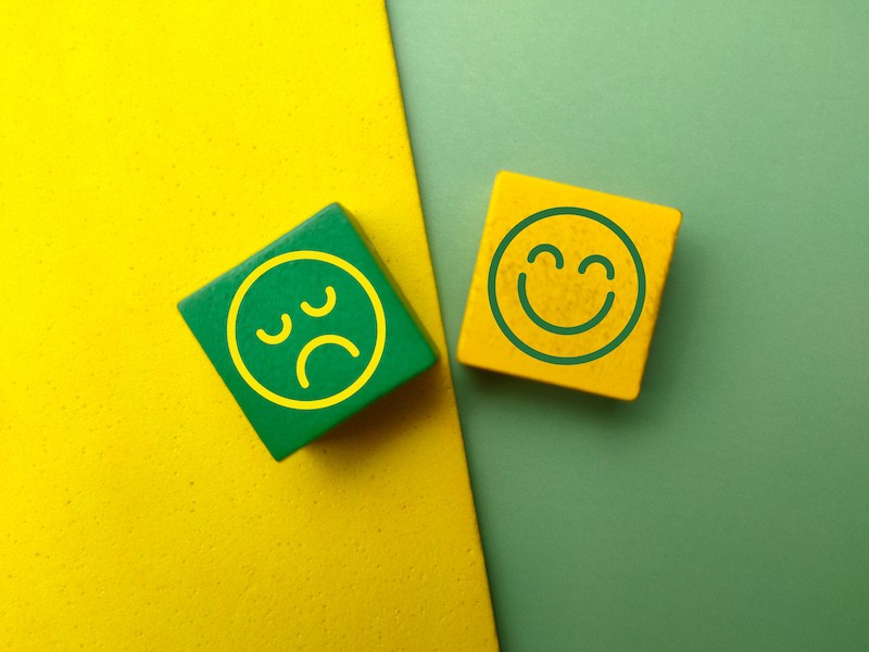 happy face and unhappy face on wooden blocks representing buyer reviews