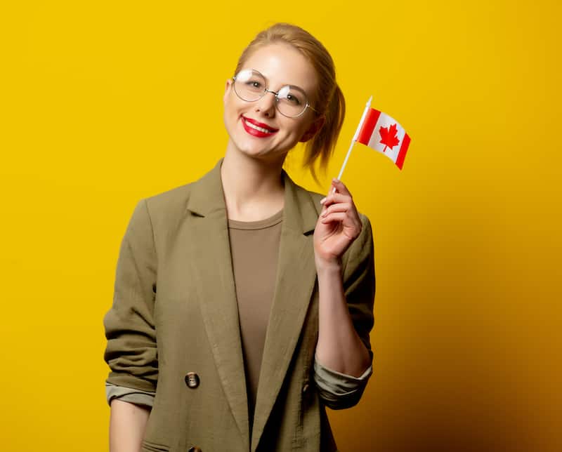 Woman smiling holding Canadian flag