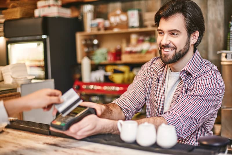Man smiling while accepting a card payment