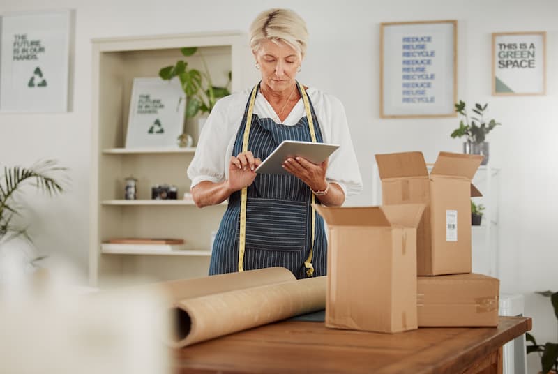 Mature business owner preparing packages for shipping ecommerce products