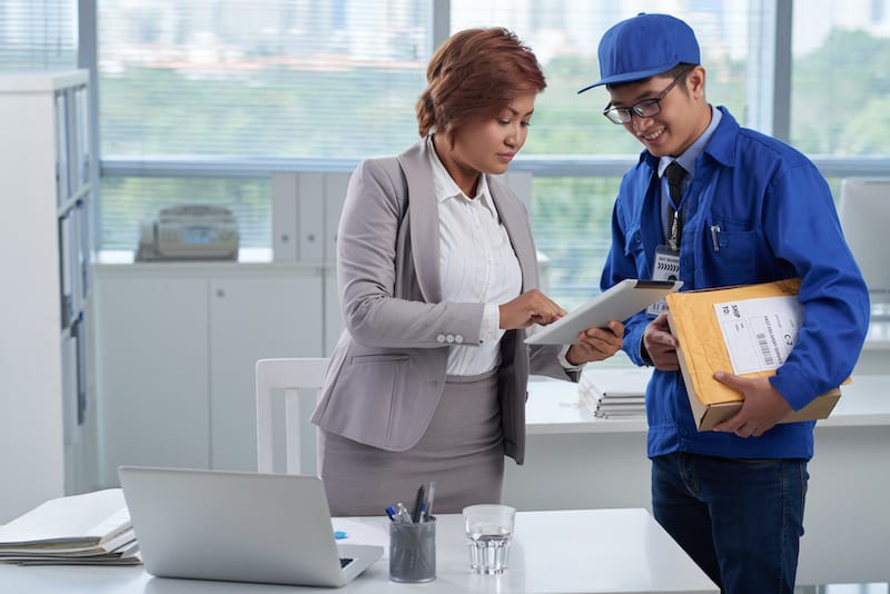 Business person talking to courier and signing for a package