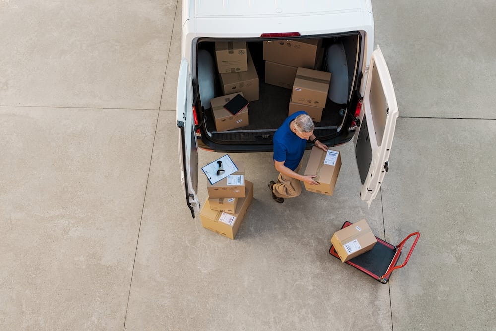 Online shipping companies man outside van with parcels