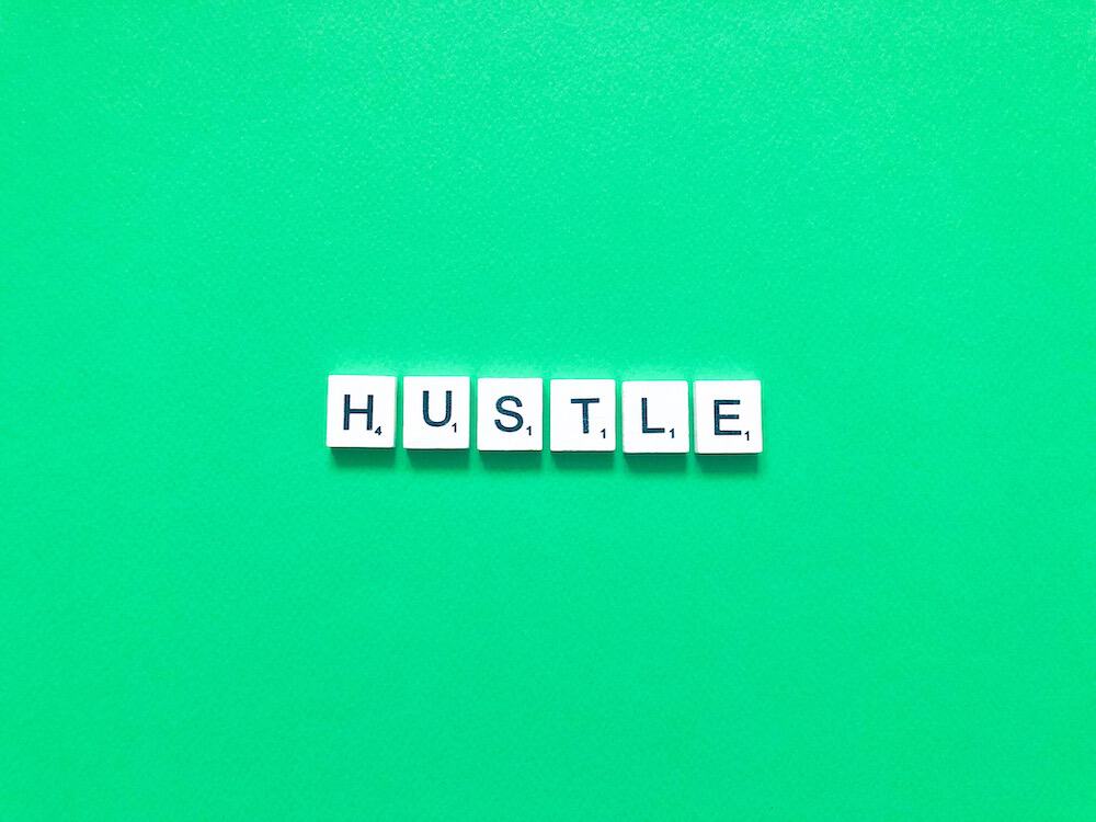 Hustle on white blocks against a green background