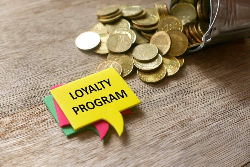 Loyalty Programs photo concept loyalty program written on sticky note with gold coins around